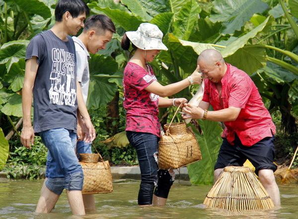 身背鱼篓,手拿鱼罩,看准塘里的大鱼,一个旋罩下去,乖乖,大鱼就在里面.