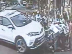 摩托车被卷入车底 青岛十余路人徒手抬车施救