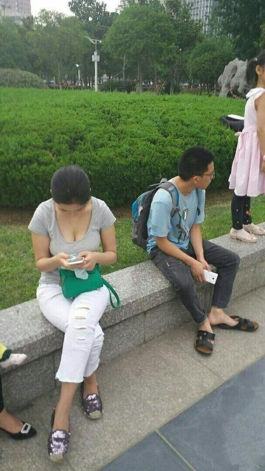 公园街拍与性感女坐在一起小哥很尴尬