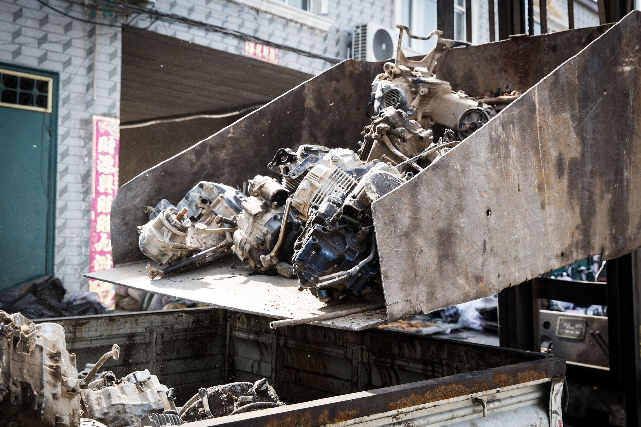 废旧摩托车被送到回收站做拆解处理,发动机堆