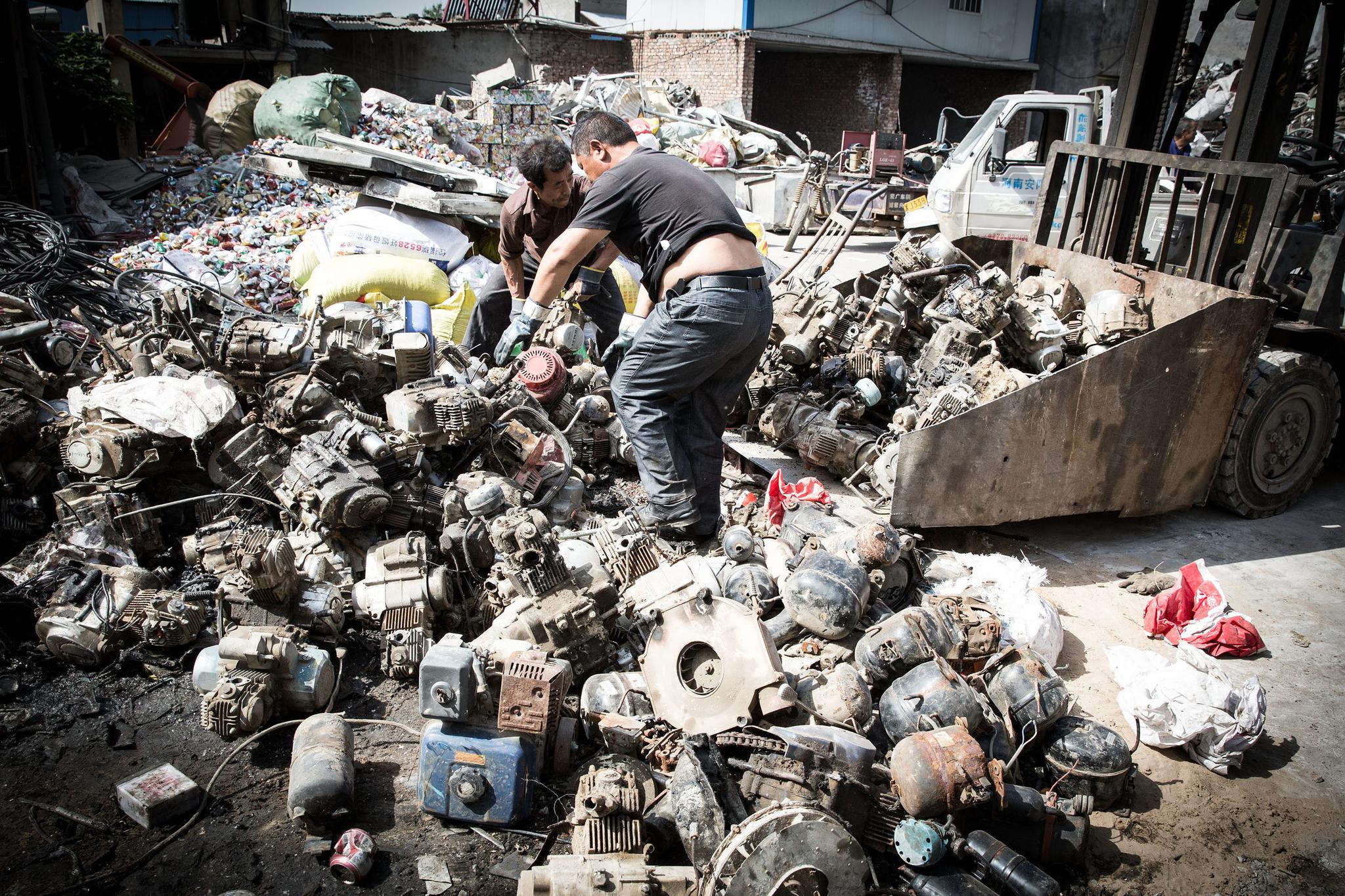 废旧摩托车被送到回收站做拆解处理,发动机堆