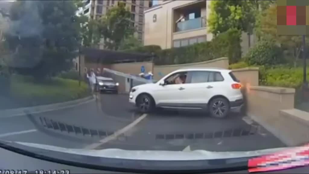 白色SUV调头倒车，撞到墙上以后，我才看清楚驾驶员是女司机