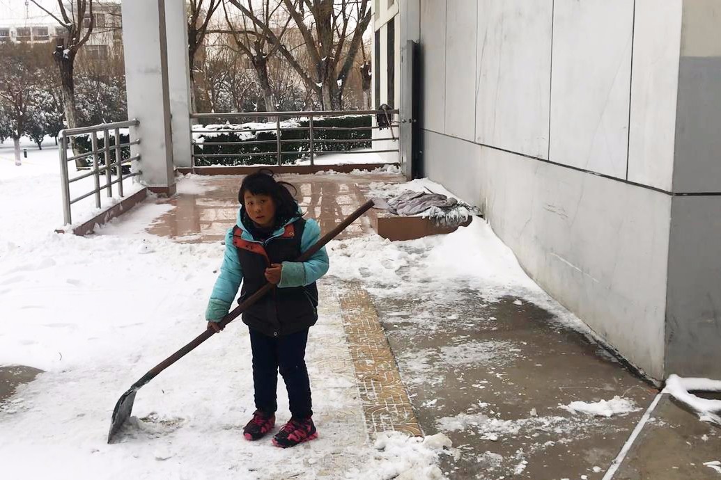 超萌小学生拿起铁锹校园里帮环卫铲雪