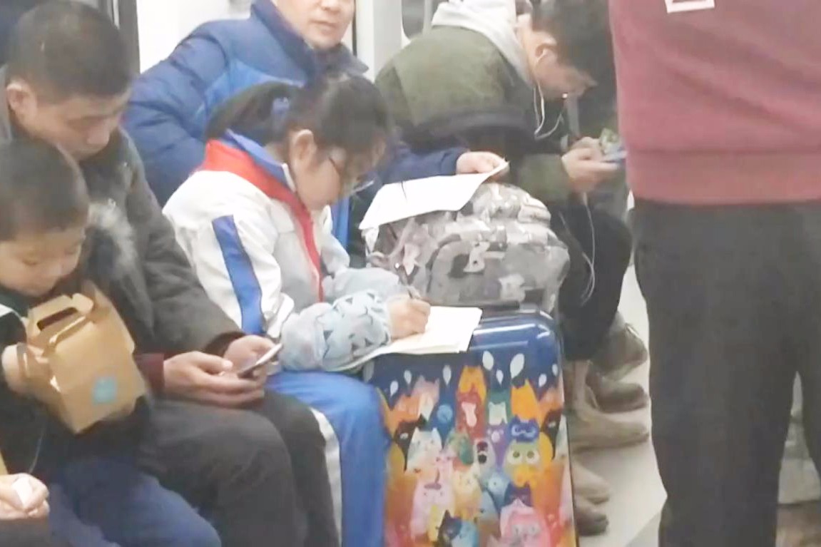 小学生地铁里写作业 父亲一旁指导,网友心疼