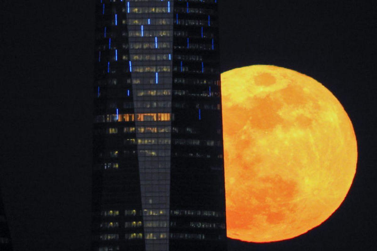 2018年1月31日,西班牙马德里,超级月亮在摩天大楼旁边升.