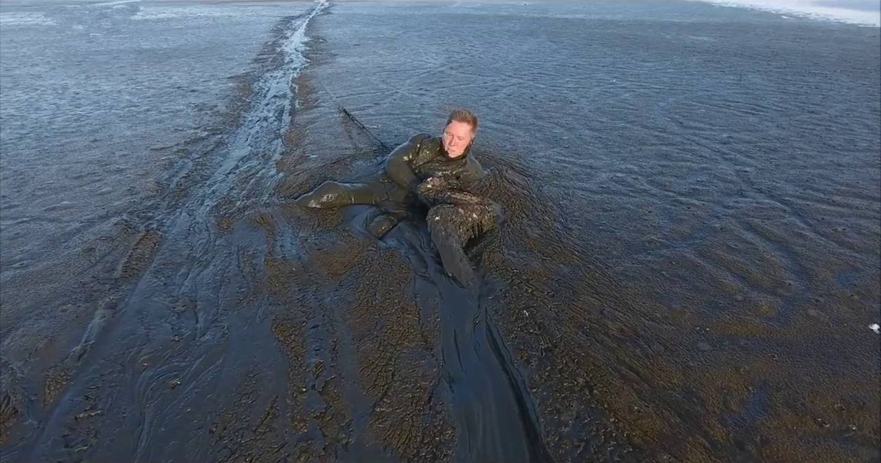 老鹰觅食不慎陷入泥潭，男子见后不顾危险奋力施救