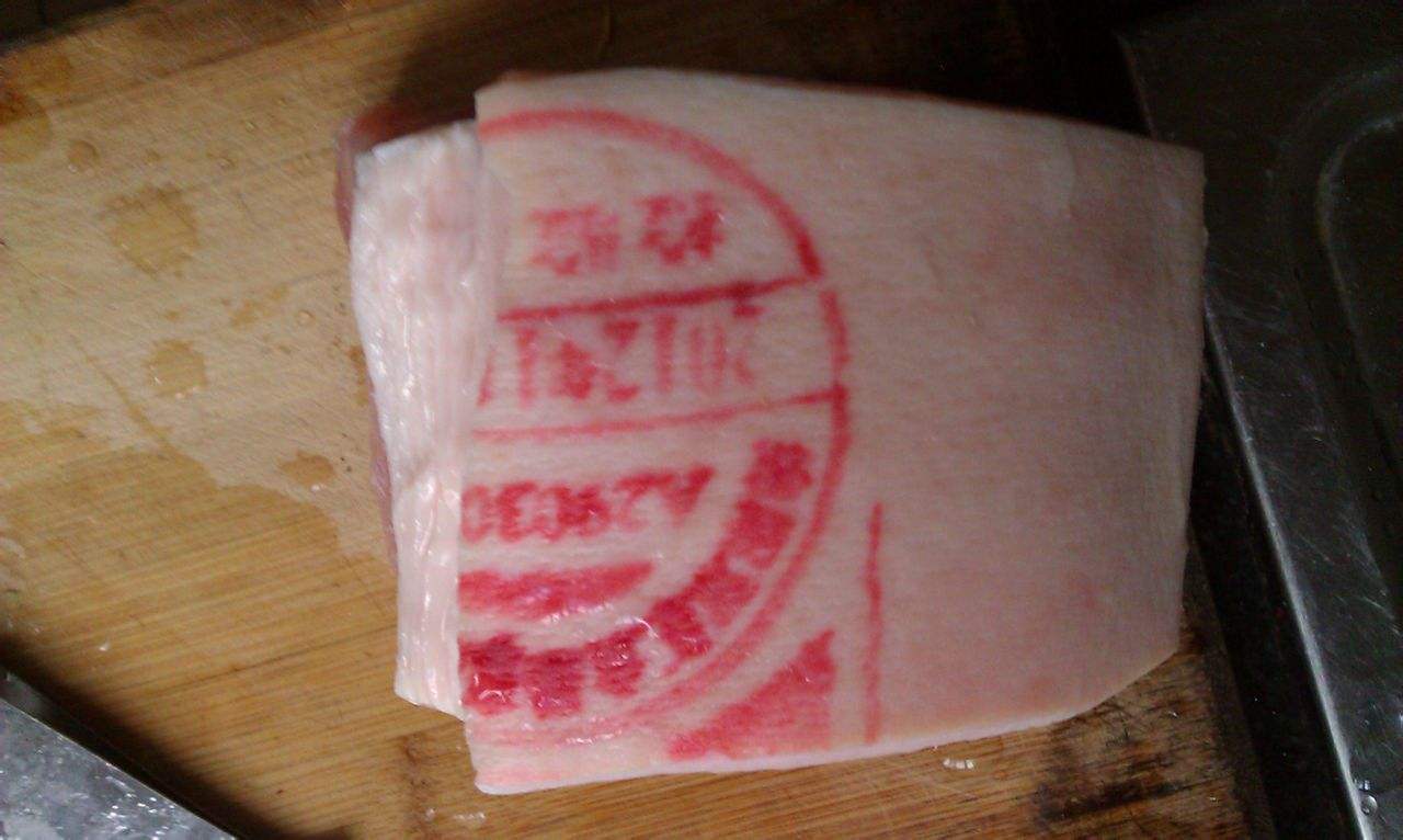 检疫合格后,动物检疫工作人员会在猪肉上盖上蓝色的检疫章,然后屠宰厂