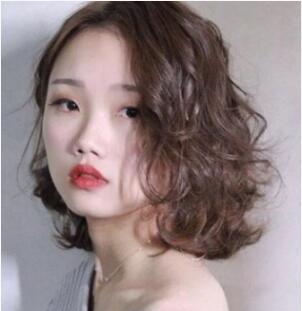 一身浅灰色系的露肩上衣,搭配上一款深棕色系的齐肩烫发发型,白皙的