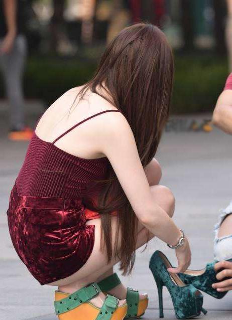 街拍:紧身短裤美女弯腰穿高跟,尽收男生视线