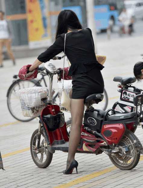 骑电动车的美女, 以职业包臀裙, 搭配时尚包包, 半卷发抒发出气