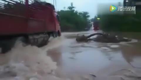 实拍大卡车雨天涉水前行 在路上侧翻消失