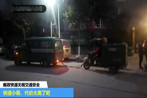 一辆邮政快递面包车牵引着一电动三轮车送快递,无视交通安全