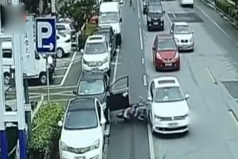 轿车开门太突然 扇飞过路电动车