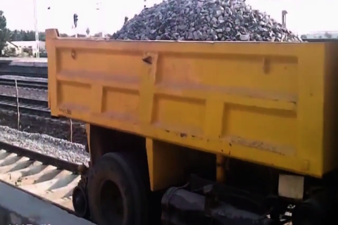 印度铁路实拍，工人驾驶卡车在铁轨上卸石子