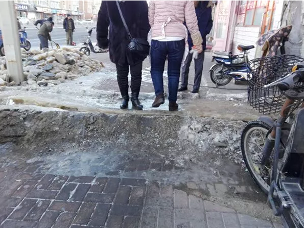 齐市红星小区轻工楼污水流成冰包和冰场,行人