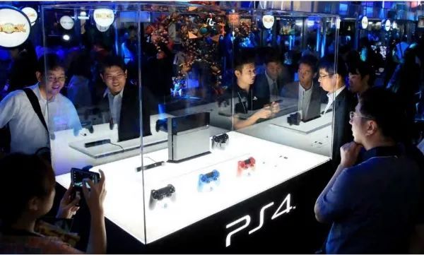 访客和媒体记者在2013年的东京电玩展上参观PS4游戏机