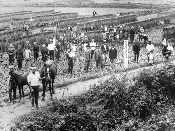 1940年农田里的合影,中间两个西装革履却穿着长套鞋的,应该是来指导