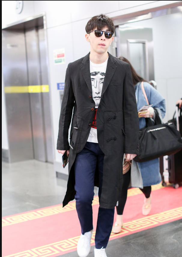 邓伦穿黑色风衣现身机场 拎黑色大包包简约有