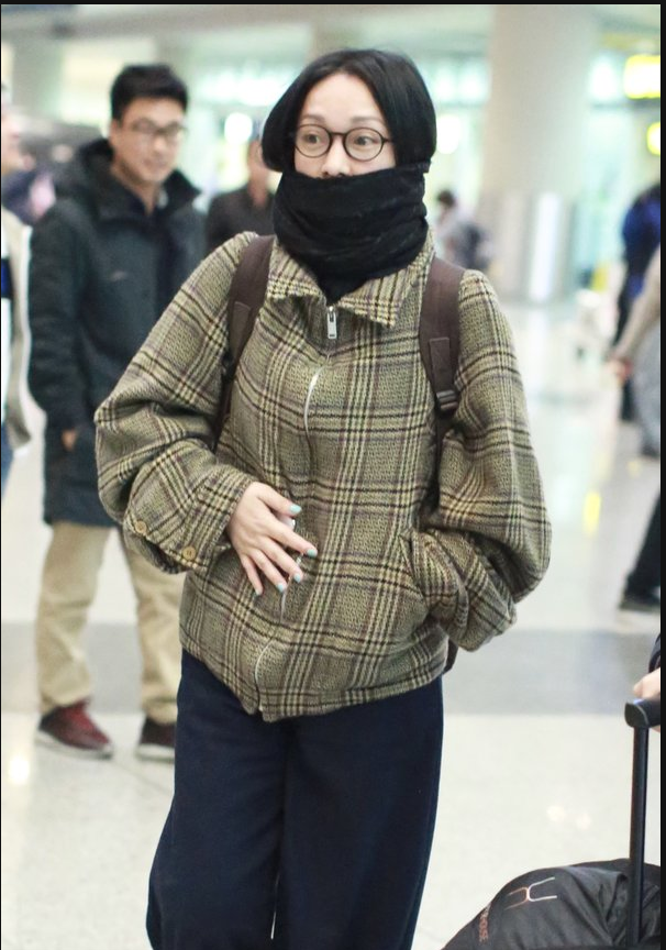 周迅素颜现身机场 黑色围巾搭配双肩包温暖简