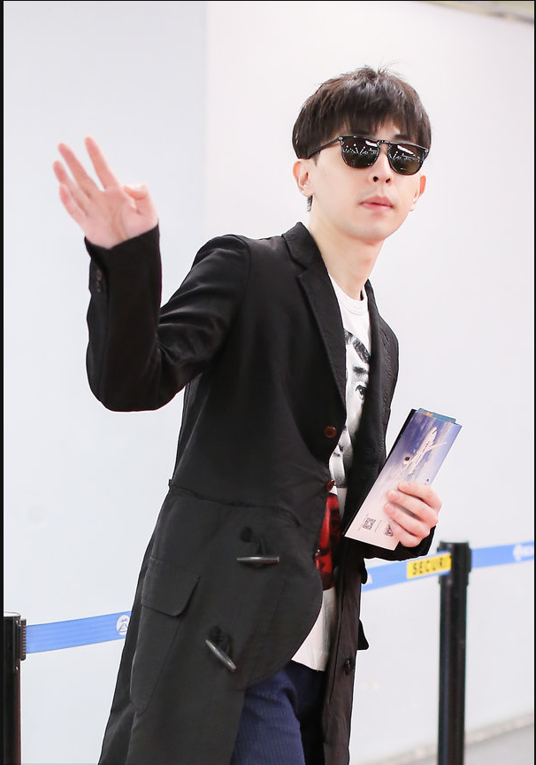 邓伦穿黑色风衣现身机场 拎黑色大包包简约有