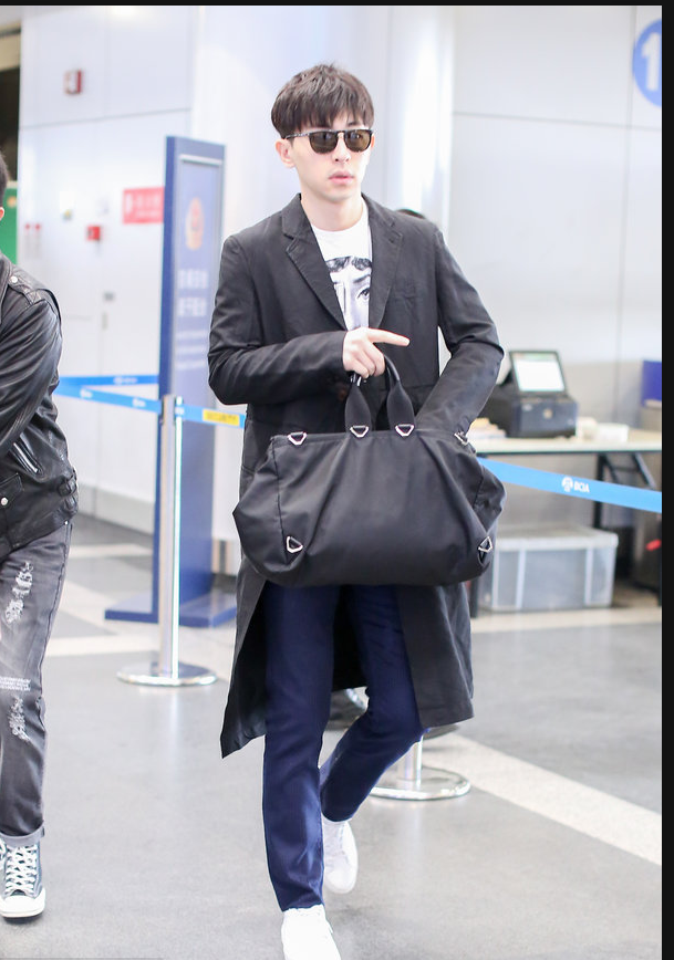 邓伦穿黑色风衣现身机场 拎黑色大包包简约有