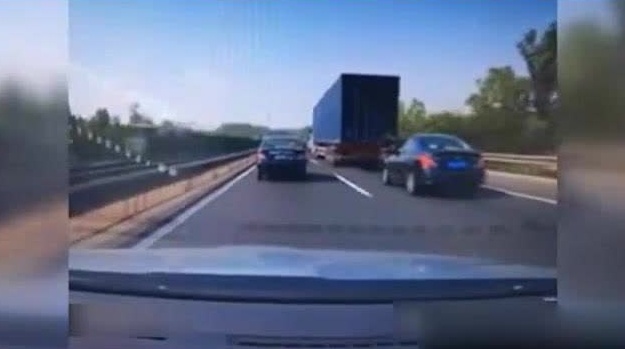 高速行车事故:中间那辆家轿被大卡车夹成纸片真惨