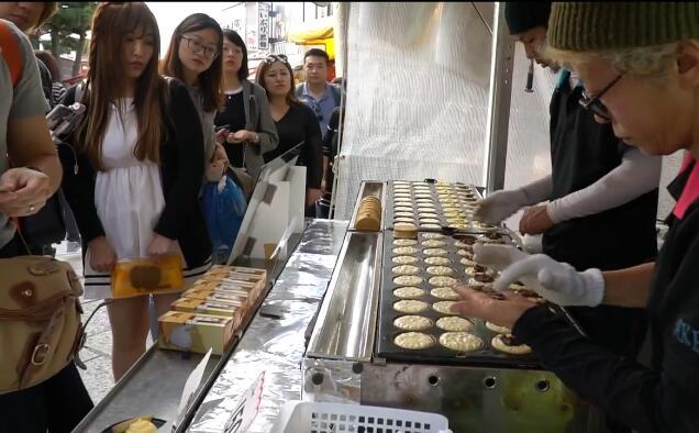 日本美女排队买车轮饼小吃 很受欢迎的芝士红豆馅