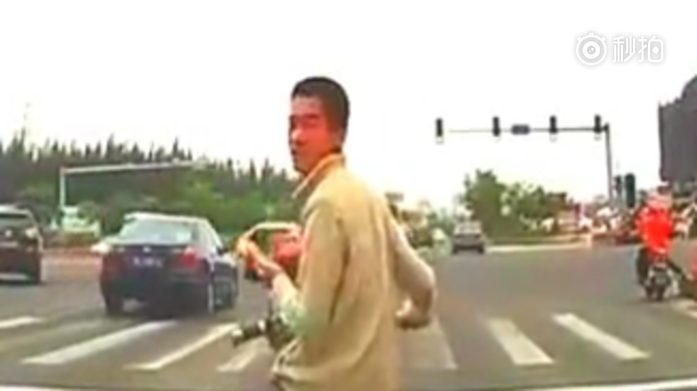 男子骑电动车占道拦车打电话，司机不撞向他就够好了