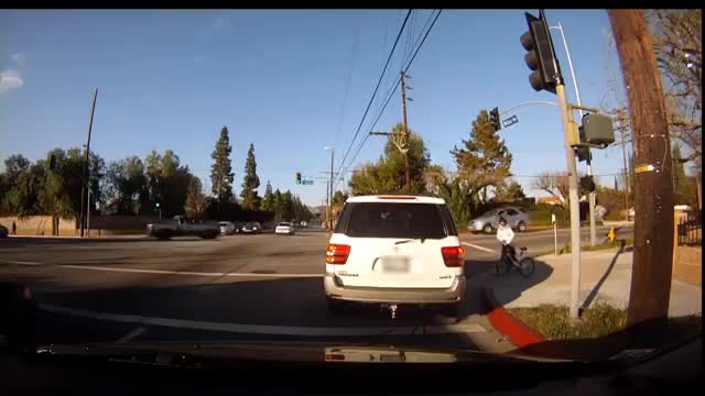 SUV转弯撞倒自行车，司机试图逃逸，看看后车司机是怎么做的！