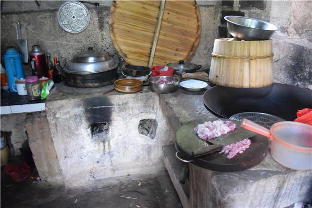 实拍农村人准备午餐土灶上一口大铁锅一边炒菜边劈柴