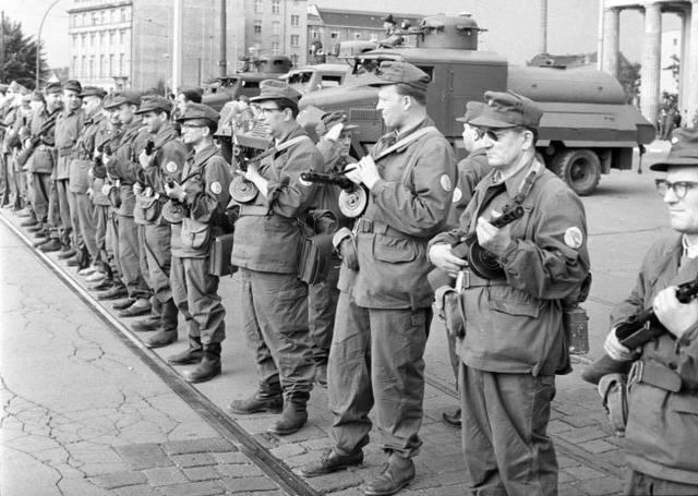 1961年,一名东德士兵帮助小男孩翻过柏林墙,全