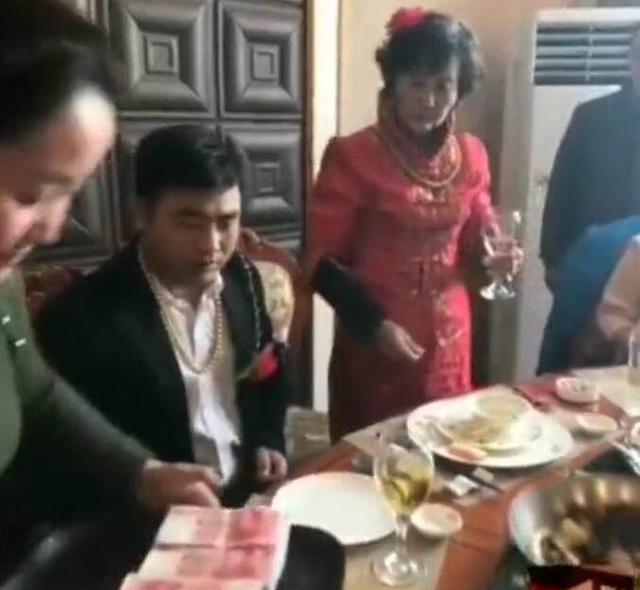 只见新娘叫助手领来了一碟东西,新郎一见,脸上显露了笑脸,站了起来和