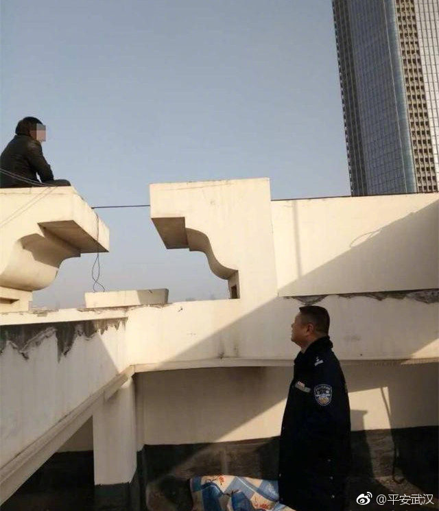 男子坐在楼顶边沿欲跳楼轻生 民警递烟劝说将其救下