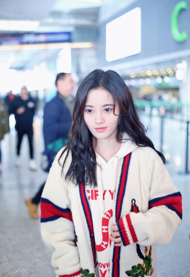 鞠婧祎现身机场,身着卫衣搭白色毛衣外套,长发披肩,清新甜美