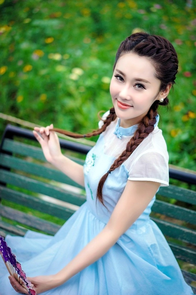 公园里一个清秀美丽,笑容怡人的小辫子姑娘