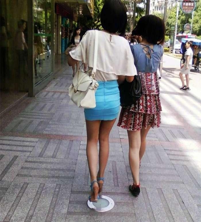 街拍穿蓝色超短包臀裙的美女与闺蜜逛街,身材