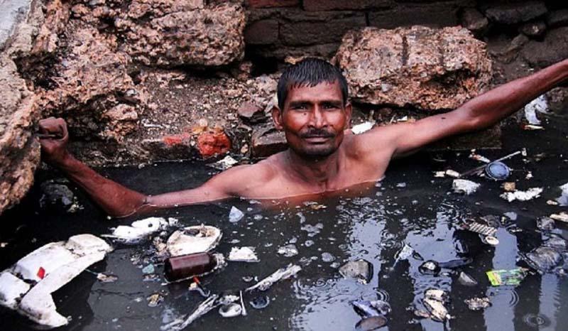站在化粪池中疏通管道 印度掏粪工人的辛酸生活