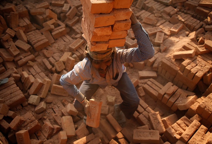 尼泊尔加德满都, 砖厂一名工人头顶砖头搬砖.