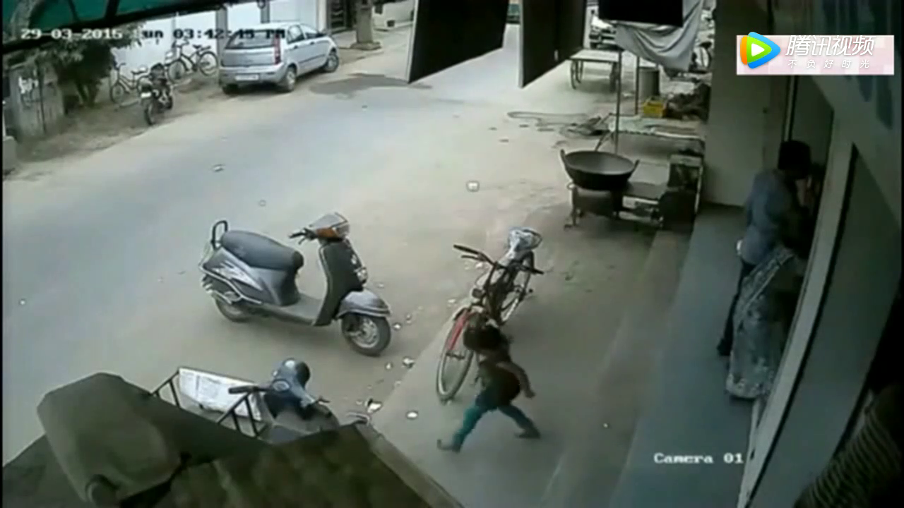 女孩坐在电动车上，爸爸在一边忙，监控突然拍下这样一幕