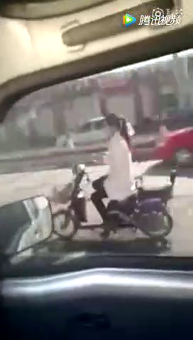 真不要命了，女子骑电动车松开车把玩手机，真是要上天了！