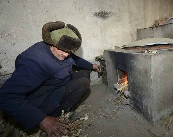 70岁村民陈淑法在烧火做饭.