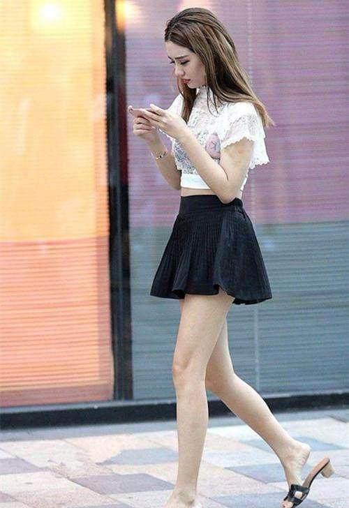 街拍美女玩手机太专心不知一阵风掀起裙子留下了唯美的画面
