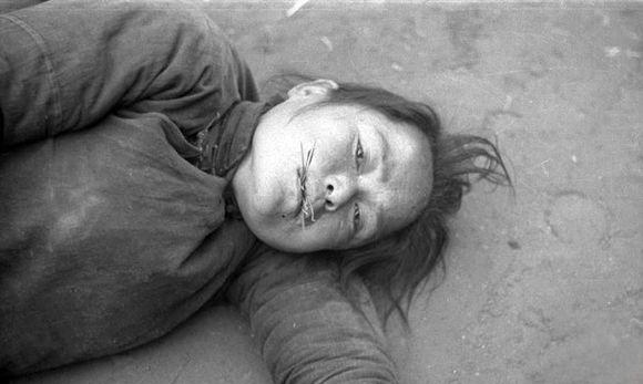 照片中的女子,饿的没东西吃只能吃草.她眼中充满绝望,正在等死.