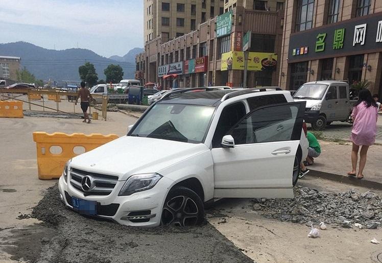 水泥刚浇上路面, 奔驰就一头扎进去, 女司机却揪着工人赔车