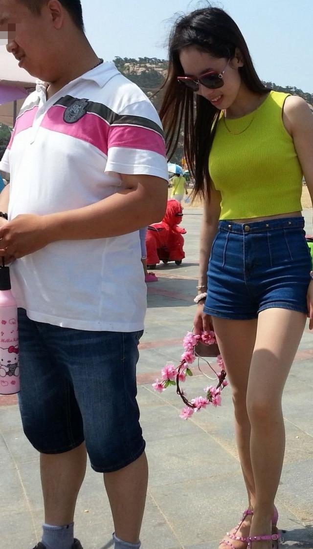 海滩实拍高腰牛仔裤的丰满美女, 紧身背心凸显曼妙曲线不输柳岩