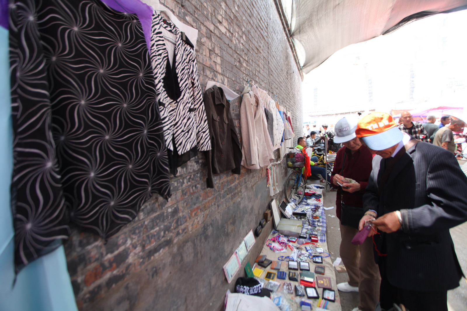 大妈赶集贩卖旧衣物 五元一件没人敢买