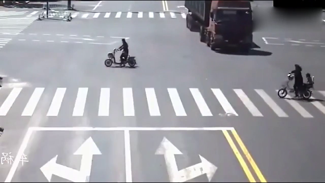 闯红灯的电动车连大货车都不放在眼里，她有没有想过身后的孩子