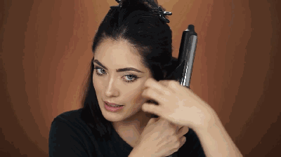 step2:然后用卷发工具对下层前中侧头发,先向内卷,再调整卷发棒角度向