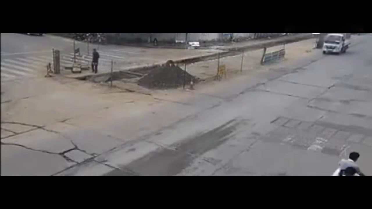 骑电动车男子真命大 水泥罐车车轮底下死里逃生