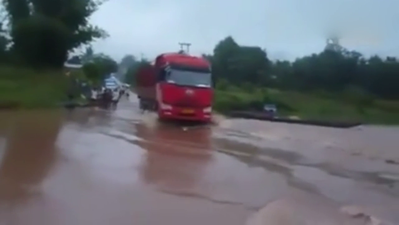 实拍大卡车雨天涉水前行 在路上侧翻消失
